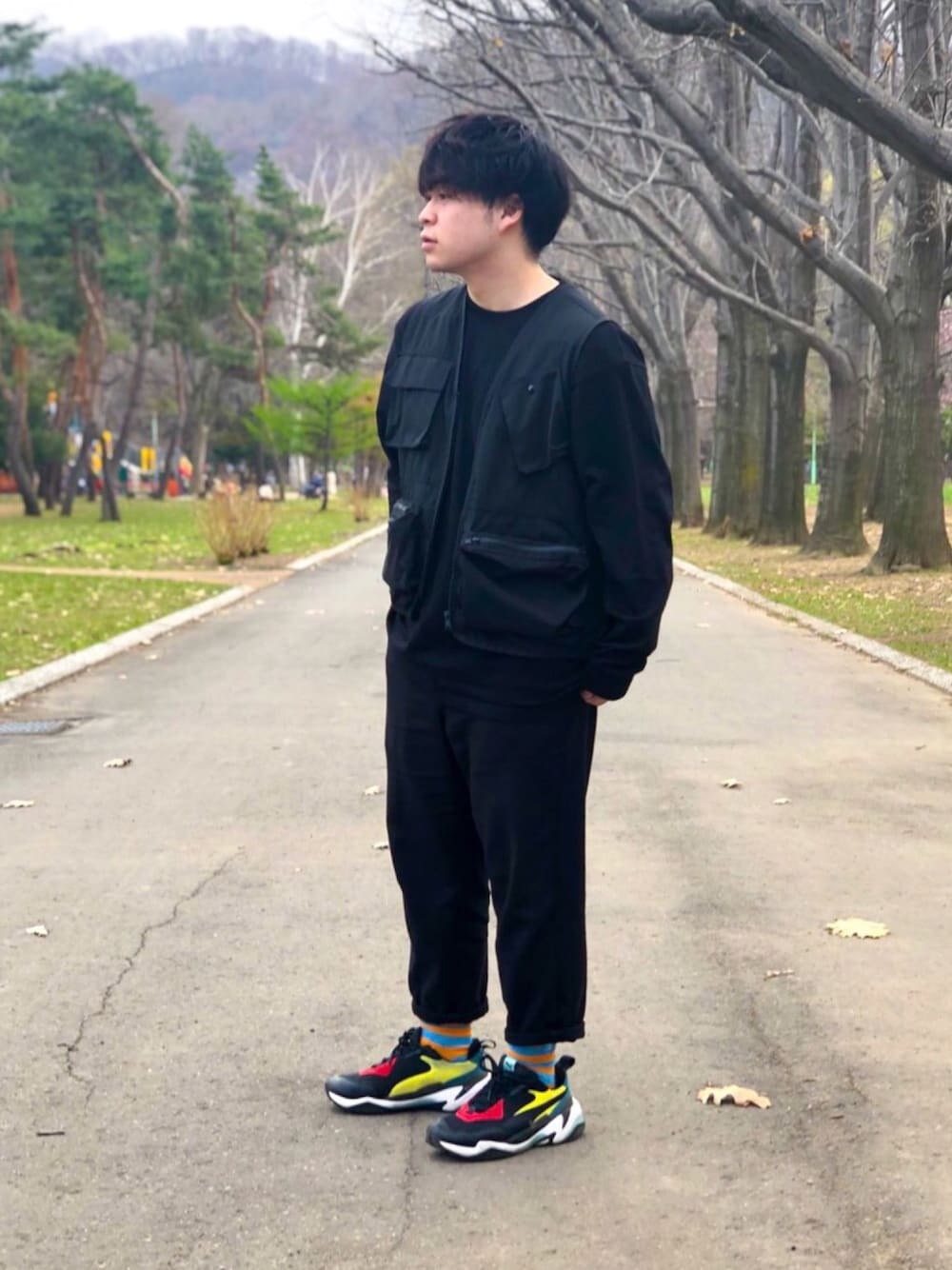 ブラック系のベスト、ブラック系のTシャツ/カットソー、ブラック系のスラックスを着用したメンズの春コーディネートの1枚目の写真