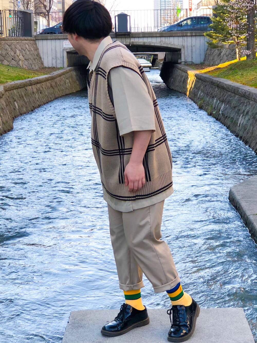 ベージュ系のベスト、ベージュ系のTシャツ/カットソー、ベージュ系のパンツを着用したメンズの春コーディネートの1枚目の写真