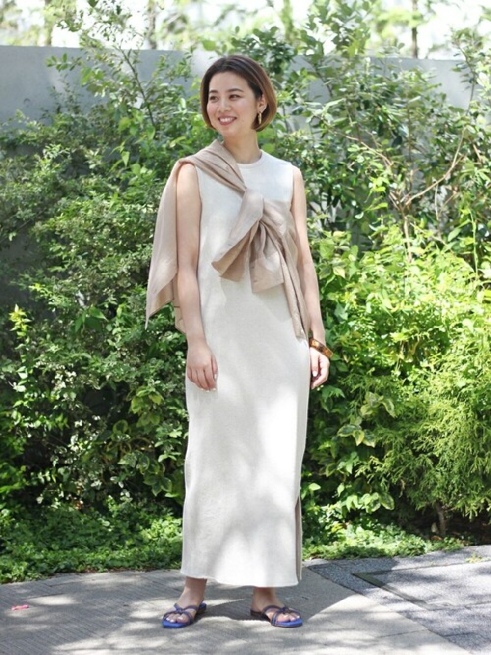 ブルー系のサンダルを着用したレディースの春コーディネートの1枚目の写真