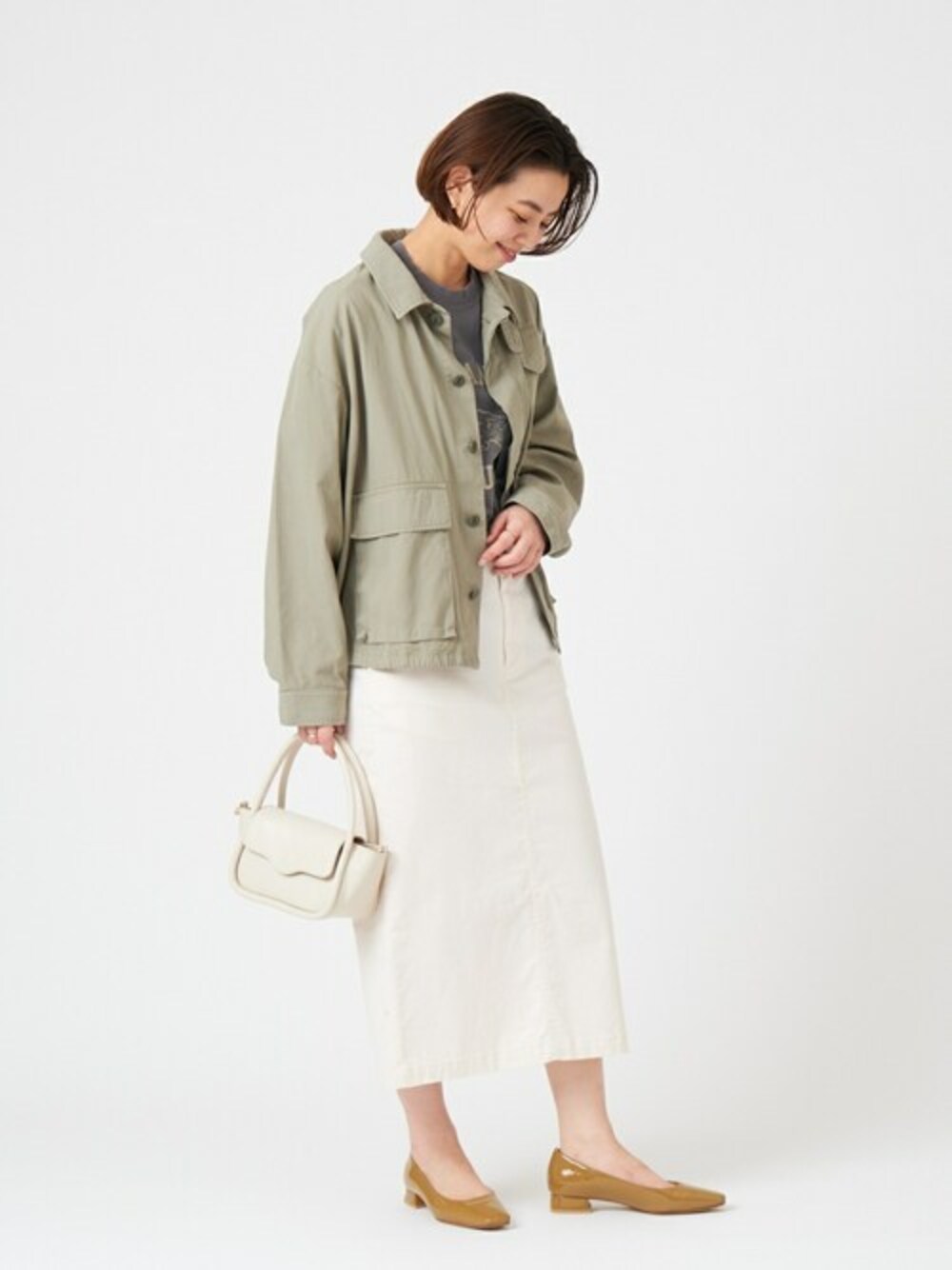 イエロー系のパンプスを着用したレディースの冬コーディネートの1枚目の写真