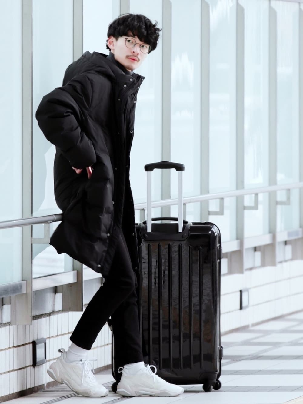 ブラック系のデニムパンツ、ホワイト系のスニーカー、ブラック系のダウンジャケット/コートを着用したメンズの秋コーディネートの1枚目の写真