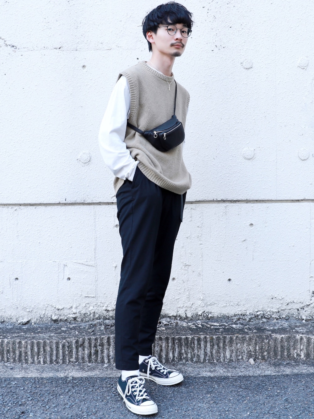 ベージュ系のベスト、ホワイト系のTシャツ/カットソー、ブラック系のスラックスを着用したメンズの春コーディネートの1枚目の写真