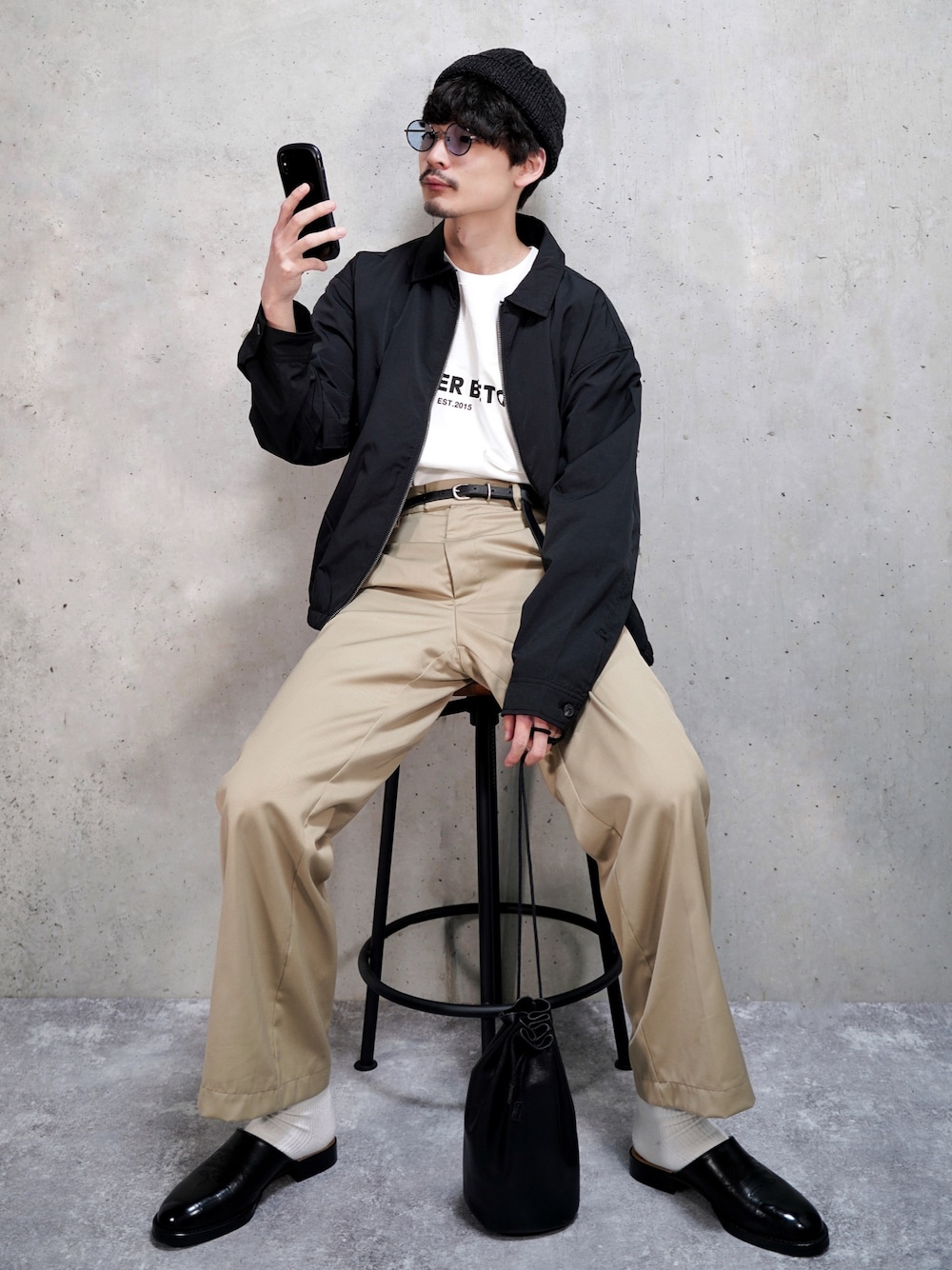 ブラック系のブルゾン、ブラック系のサンダル、ホワイト系のTシャツ/カットソーを着用したメンズの春コーディネートの1枚目の写真