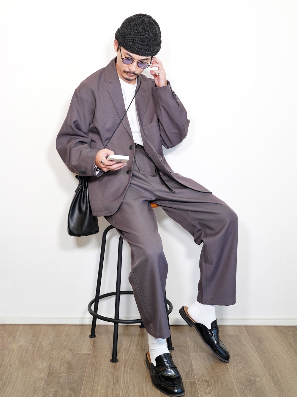 ホワイト系のTシャツ/カットソー、ブラック系のショルダーバッグ、グレー系のセットアップを着用したメンズの秋コーディネートの1枚目の写真