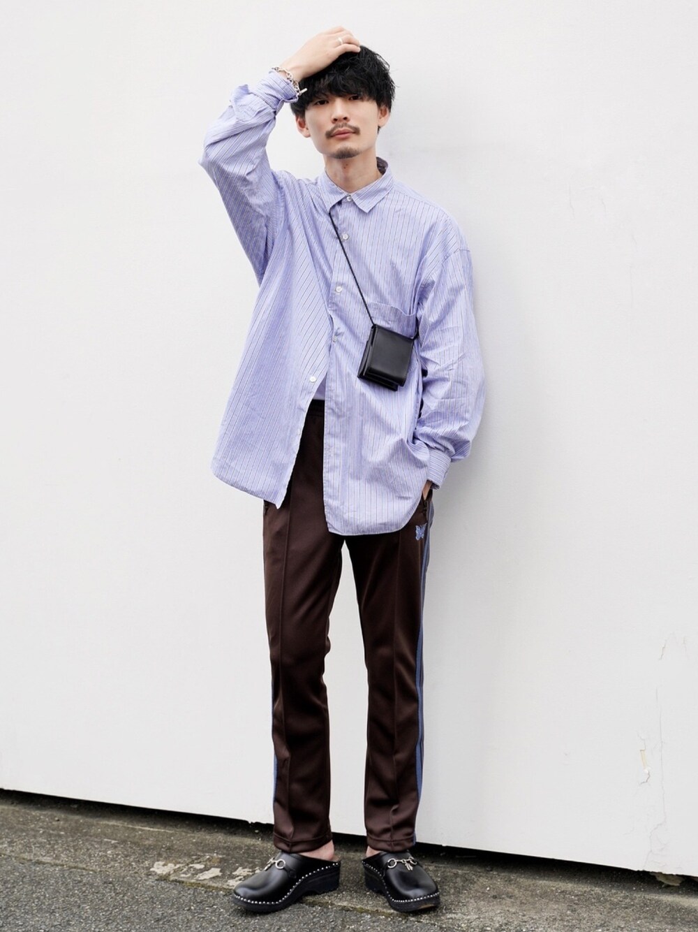 ブラック系のショルダーバッグ、ブラウン系のパンツ、ブラック系のシューズを着用したメンズの秋コーディネートの1枚目の写真