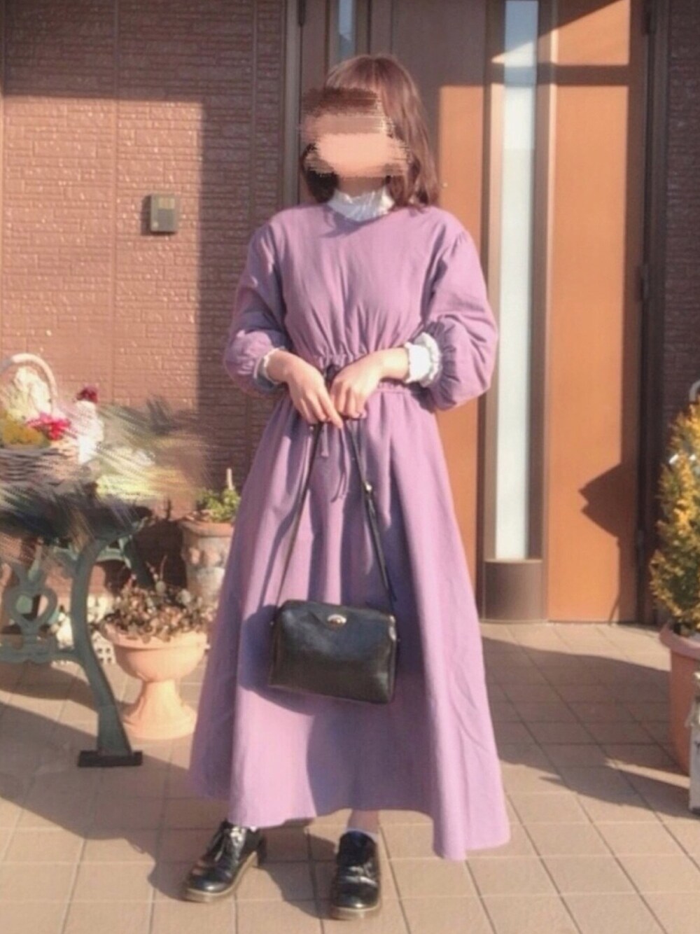 パープル系のワンピース、ブラック系のショルダーバッグ、ブラック系のドレスシューズを着用したレディースの冬コーディネートの1枚目の写真