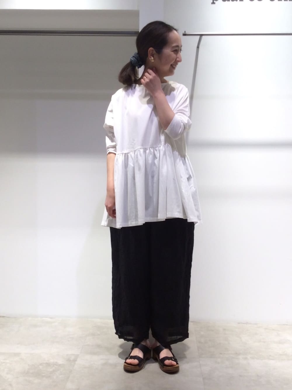 ホワイト系のTシャツ/カットソー、ブラック系のその他パンツ、ブラック系のサンダルを着用したレディースの春コーディネートの1枚目の写真