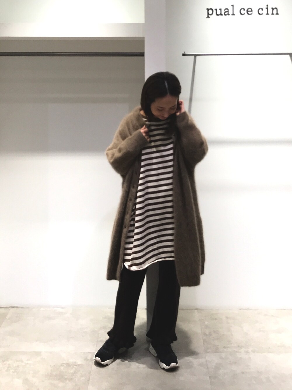 ベージュ系のカーディガン/ボレロ、ブラウン系のTシャツ/カットソー、ブラック系のその他パンツを着用したレディースの冬コーディネートの1枚目の写真