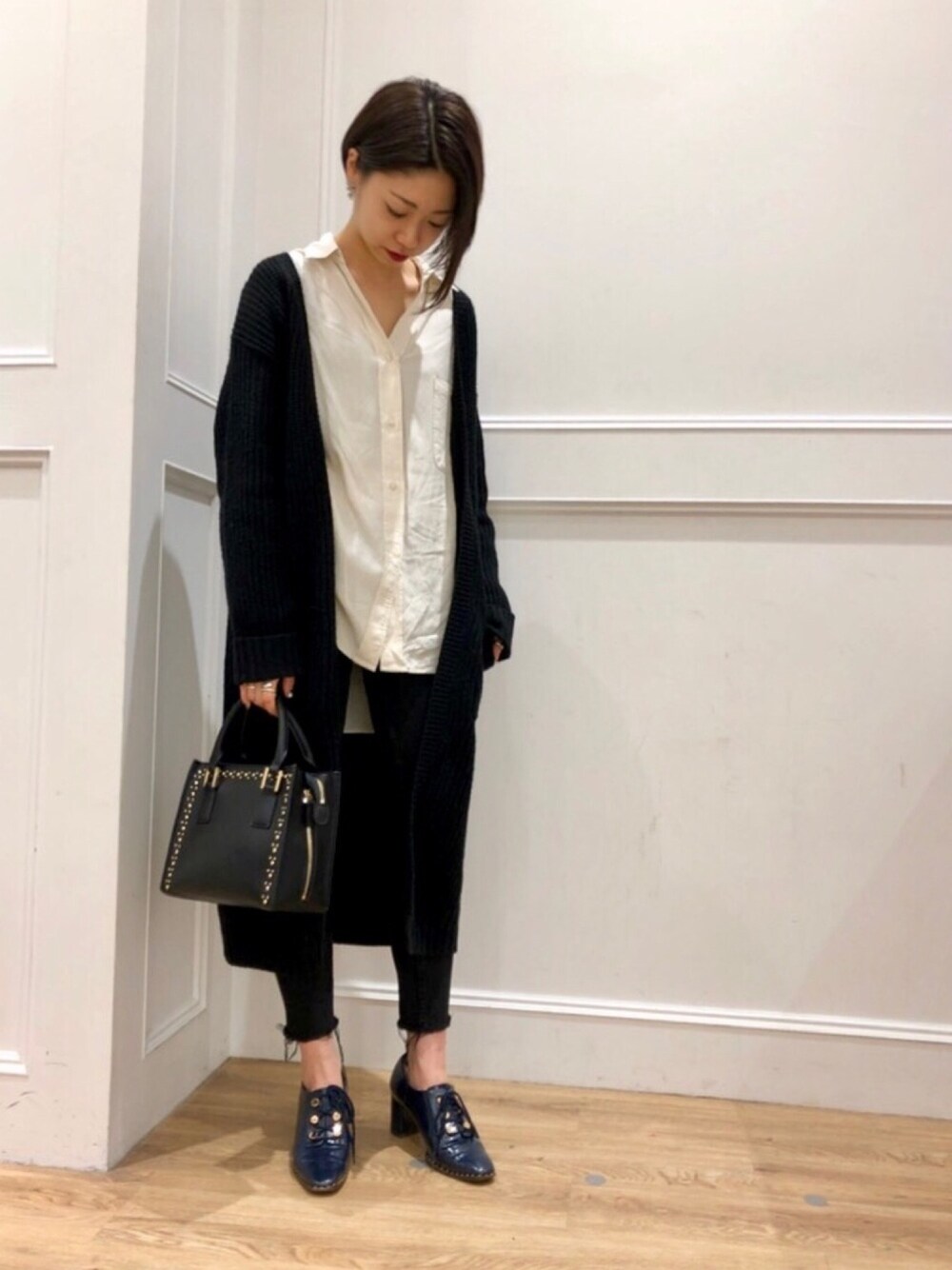 ブラック系のショルダーバッグ、ブルー系のドレスシューズを着用したレディースの冬コーディネートの1枚目の写真