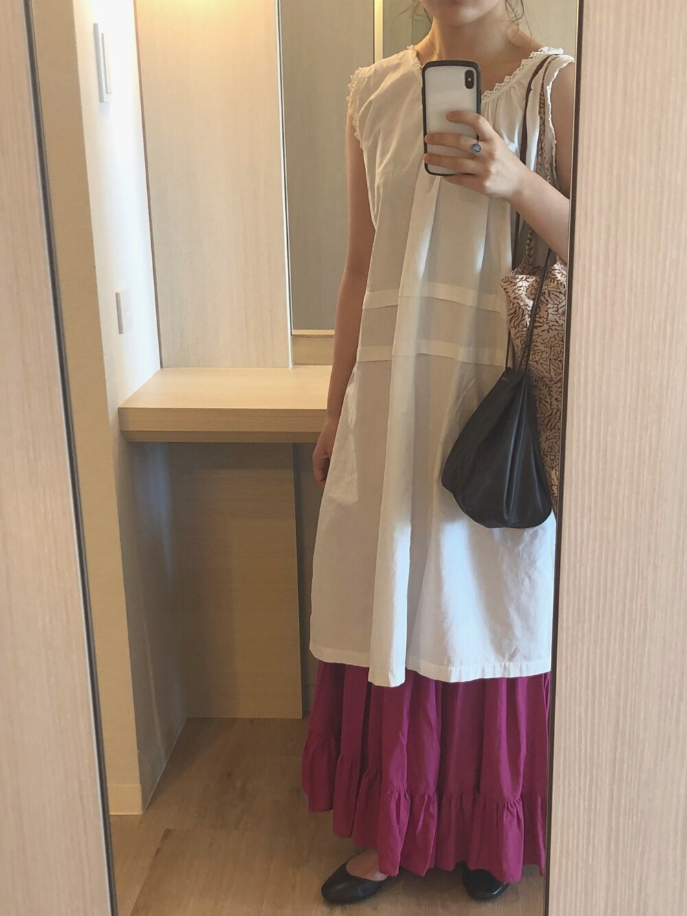 パープル系のスカート、ブラック系のシューズを着用したレディースの夏コーディネートの1枚目の写真