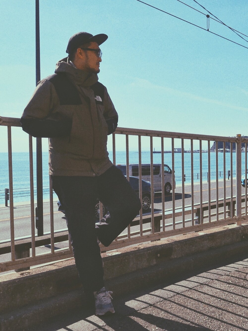 「シンプルコーデ、いいね、save、フォローお願いします🤑、冬コーデ、海、風が強い、northface、New Balance、1990s、プチプラ、キャップ」｜「THE NORTH FACEのアイテム（ダウンジャケット/コート、グリーン系）」を使った、トウゼンさん（メンズ・183cm）の春コーディネートの1枚目の写真