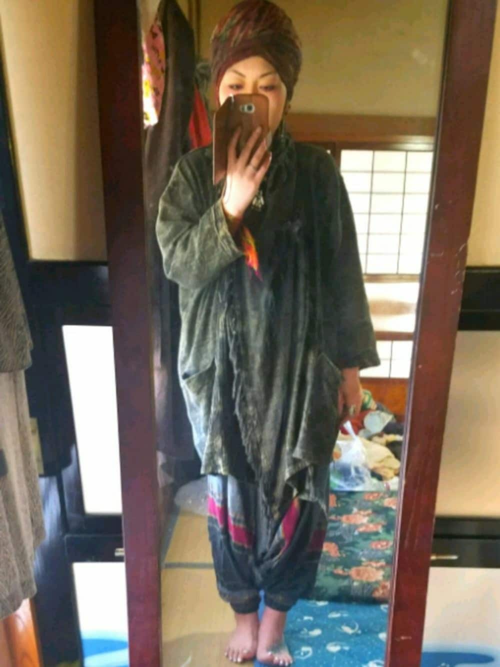 グリーン系のジャケット/アウター、グレー系のパンツ、レッド系のマフラーを着用したレディースの春コーディネートの1枚目の写真