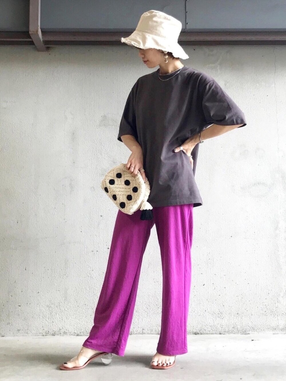 ピンク系のパンツ、グレー系のTシャツ/カットソー、ベージュ系のハットを着用したレディースの夏コーディネートの1枚目の写真