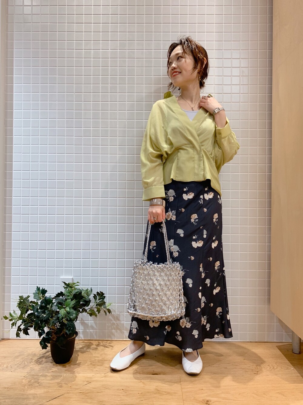 イエロー系のシャツ/ブラウス、ブラック系のスカートを着用したレディースの春コーディネートの1枚目の写真