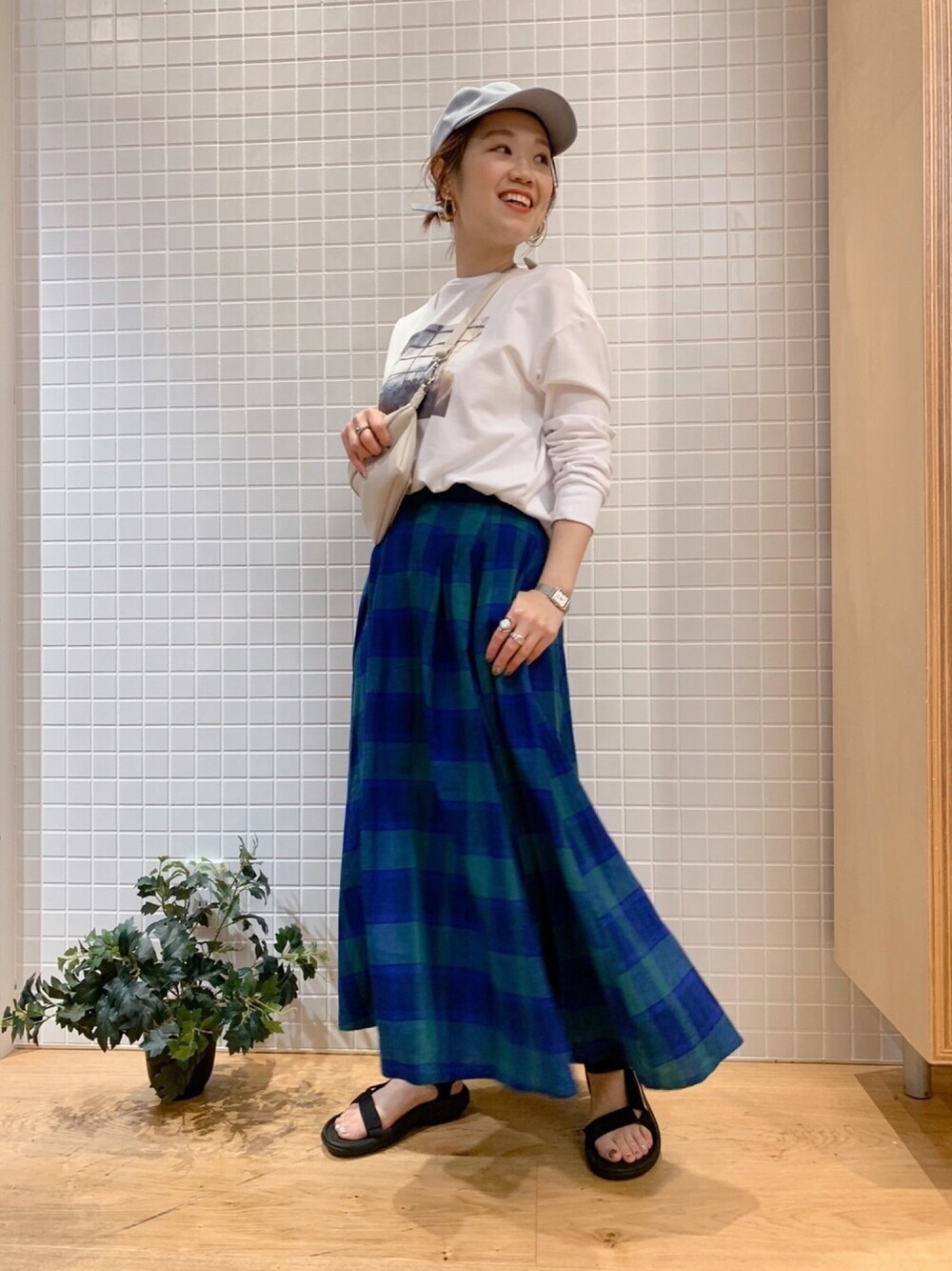 ブルー系のスカート、ホワイト系のTシャツ/カットソーを着用したレディースの春コーディネートの1枚目の写真