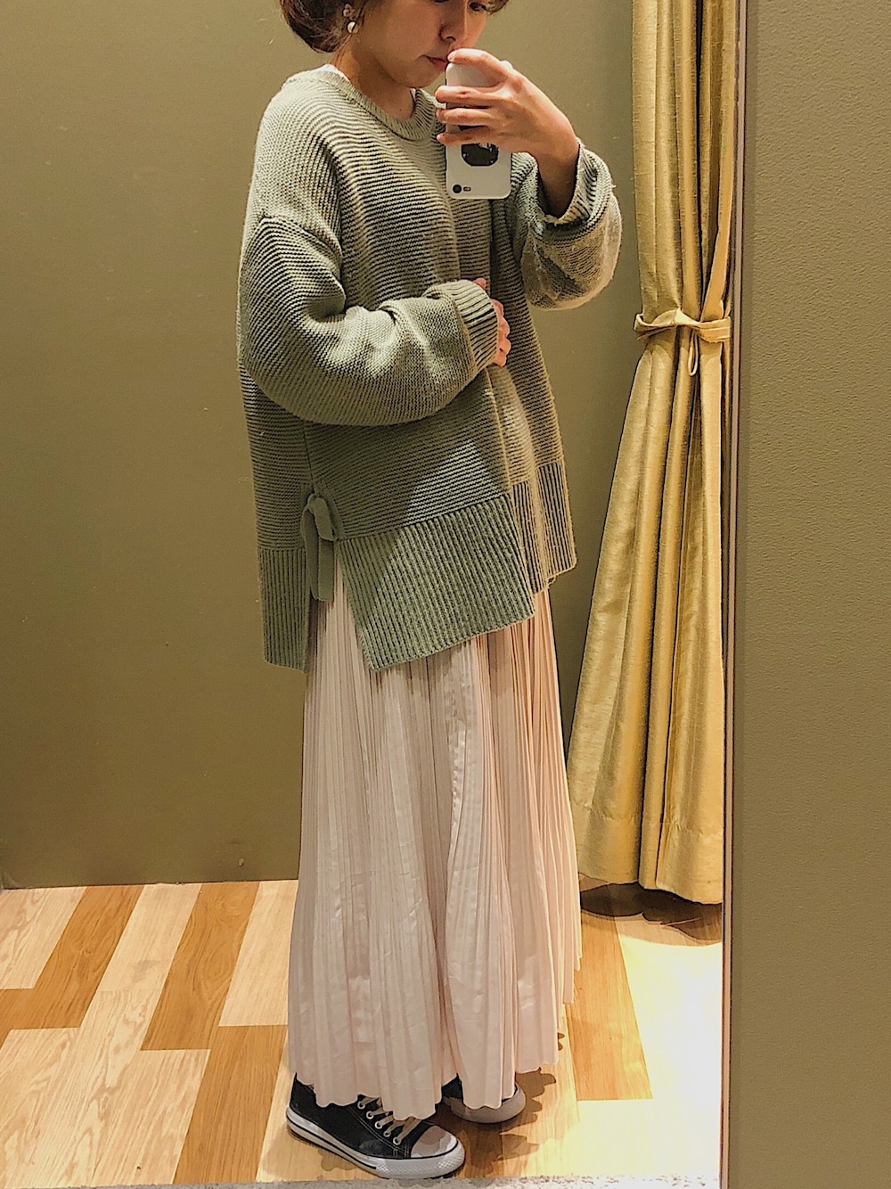 グリーン系のニット/セーター、ホワイト系のスカートを着用したレディースの冬コーディネートの1枚目の写真