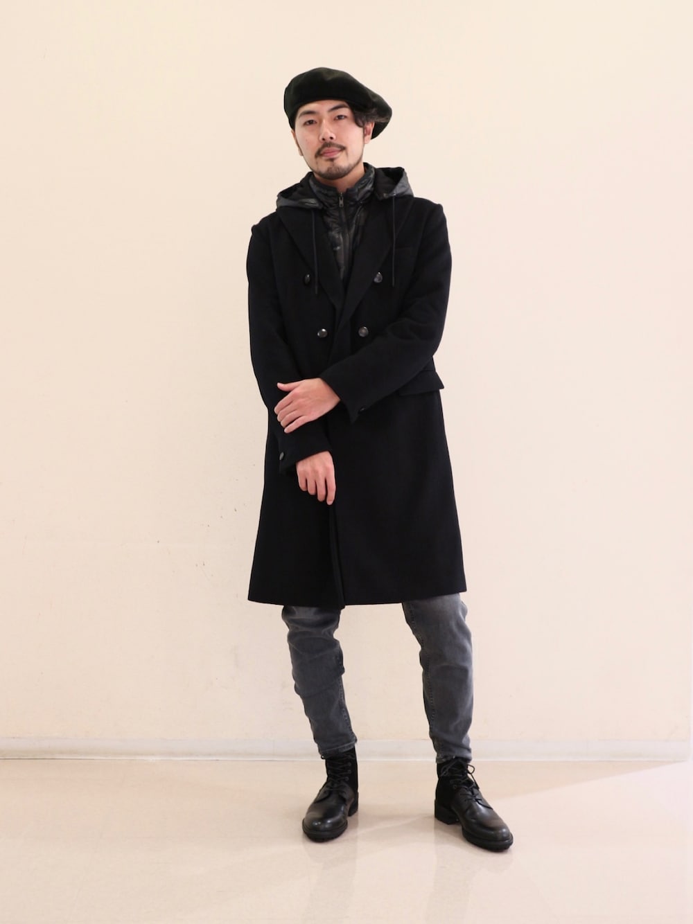 ブラック系のチェスターコート、ブルー系のその他パンツ、ブラック系のブーツを着用したメンズの冬コーディネートの1枚目の写真