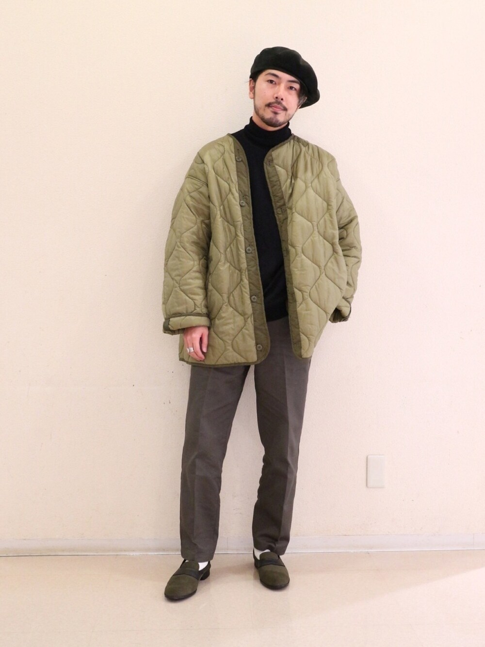グリーン系のローファー、グリーン系のパンツを着用したメンズの冬コーディネートの1枚目の写真