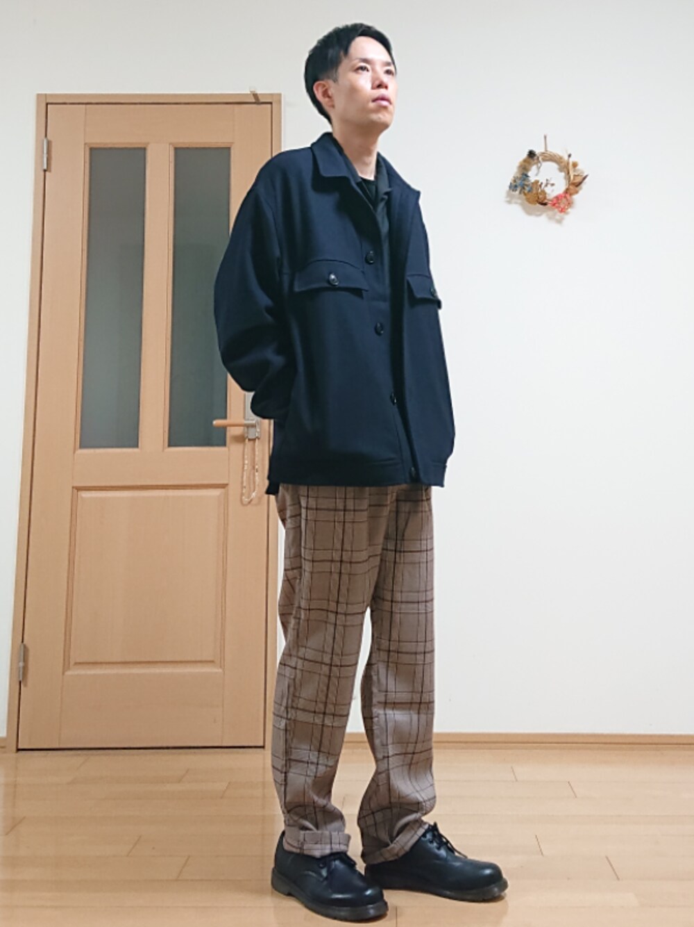 ブルー系のミリタリージャケット、ブラウン系のスラックス、ブラック系のシャツ/ブラウスを着用したメンズの秋コーディネートの1枚目の写真