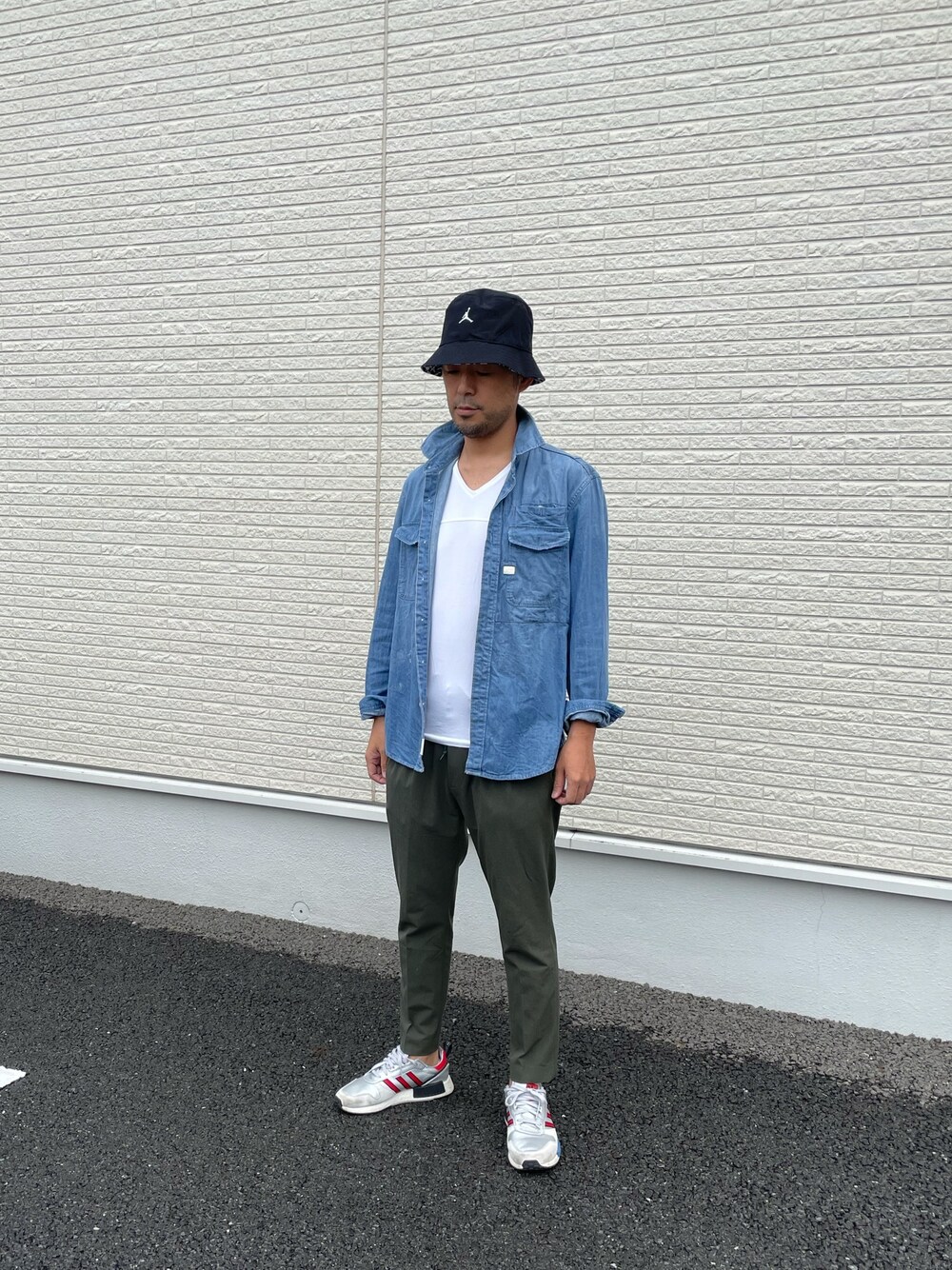 ブルー系のシャツ/ブラウス、グリーン系のスラックス、シルバー系のスニーカーを着用したメンズの春コーディネートの1枚目の写真