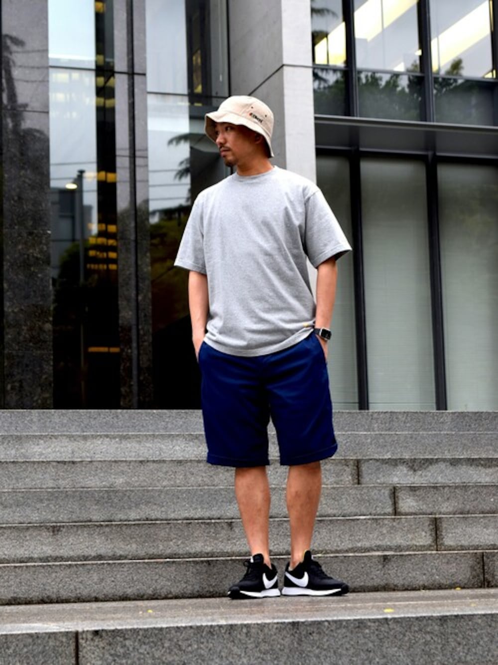 「NIKE、グレー、ストリート、backchannel、ハーフパンツ、シンプルコーデ、夏コーデ、バケットハット、無地T、バックチャンネル」｜「Back ChannelのSTRETCH CHINO PANTS（チノパンツ、ブルー系）」を使った、Back Channel®︎さん（メンズ・175cm）の春コーディネートの1枚目の写真