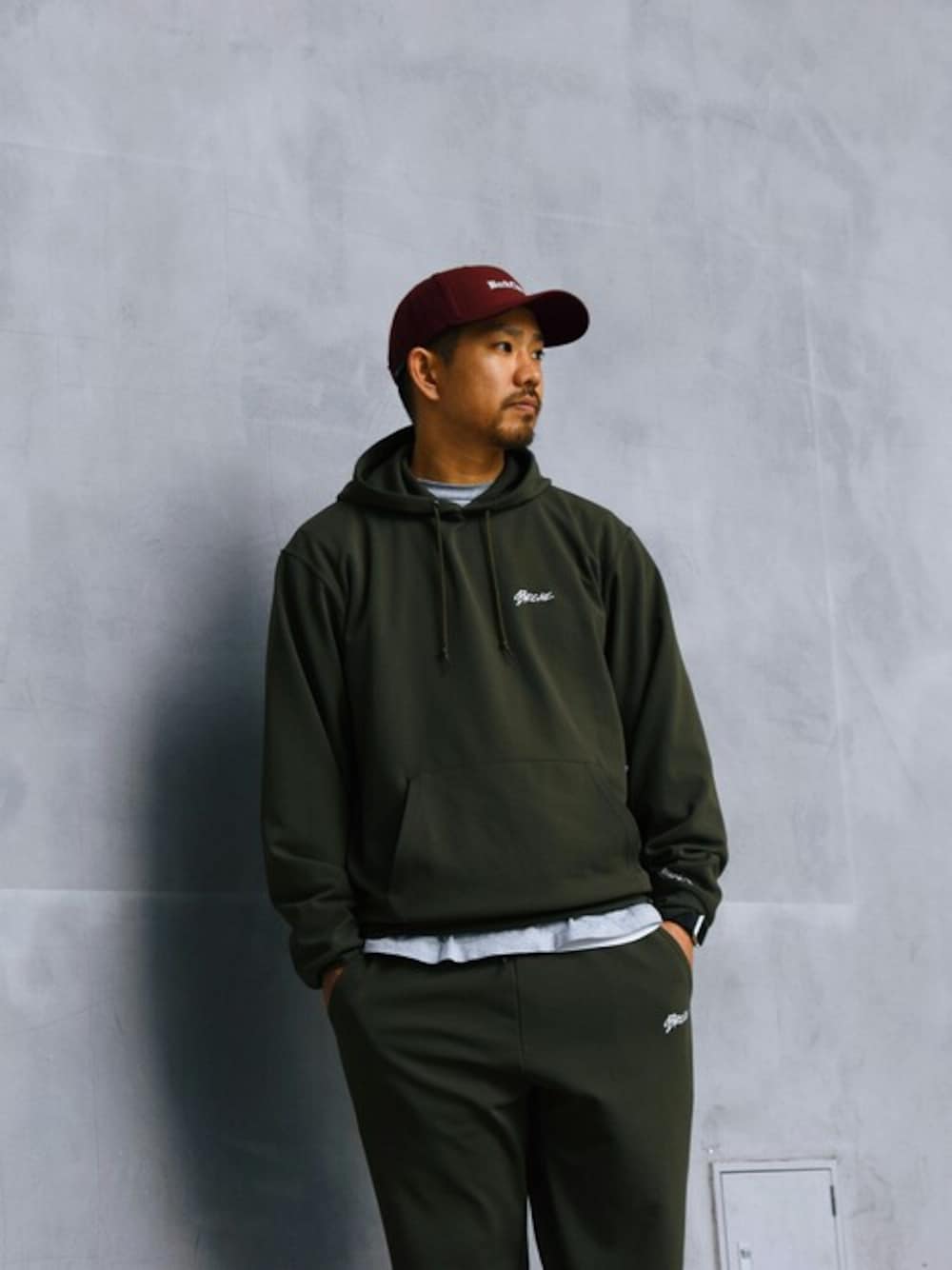 「スウェットパンツ、セットアップ、キャップ、ストリート、カーキ、backchannel、スポーツミックス、ワインレッド、春コーデ、スウェパカ」｜「Back ChannelのDRY STRETCH PULLOVER PARKA（パーカー、グリーン系）」を使った、Back Channel®︎さん（メンズ・175cm）の春コーディネートの1枚目の写真