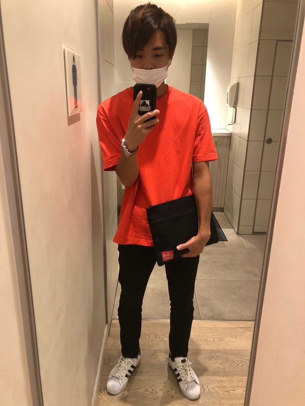 「シンプルコーデ、オレンジ、トイレから失礼しやす、クラッチバッグ、Tシャツ、GAP、Levi's、黒ジーンズ、adidas originals、スーパースタン」｜「GAPのイージーtシャツ（Tシャツ/カットソー、オレンジ系）」を使った、TOMOKIさん（メンズ・175cm）の秋コーディネートの1枚目の写真