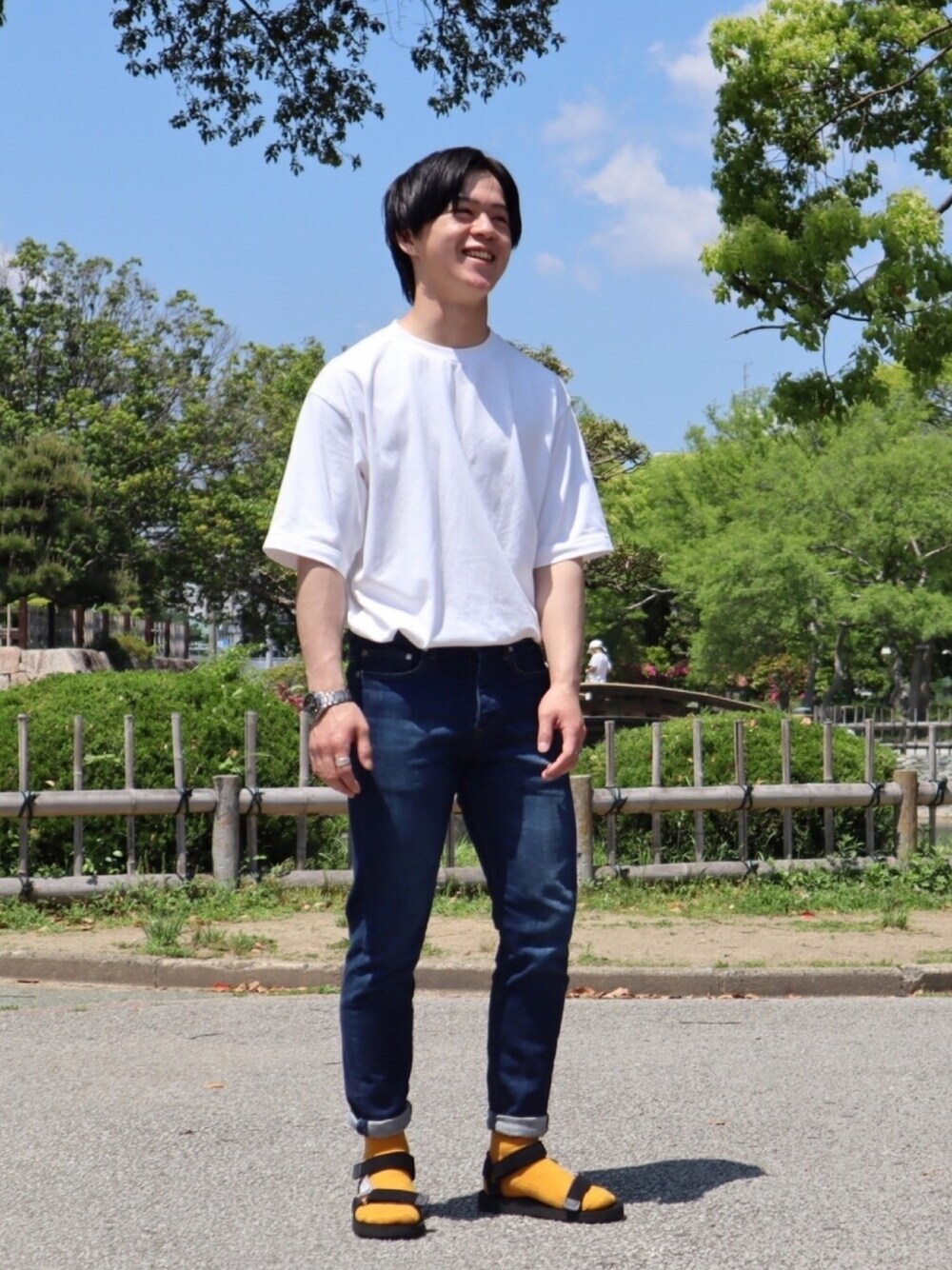 ホワイト系のTシャツ/カットソー、ブルー系のデニムパンツ、ブラック系のサンダルを着用したメンズの春コーディネートの1枚目の写真