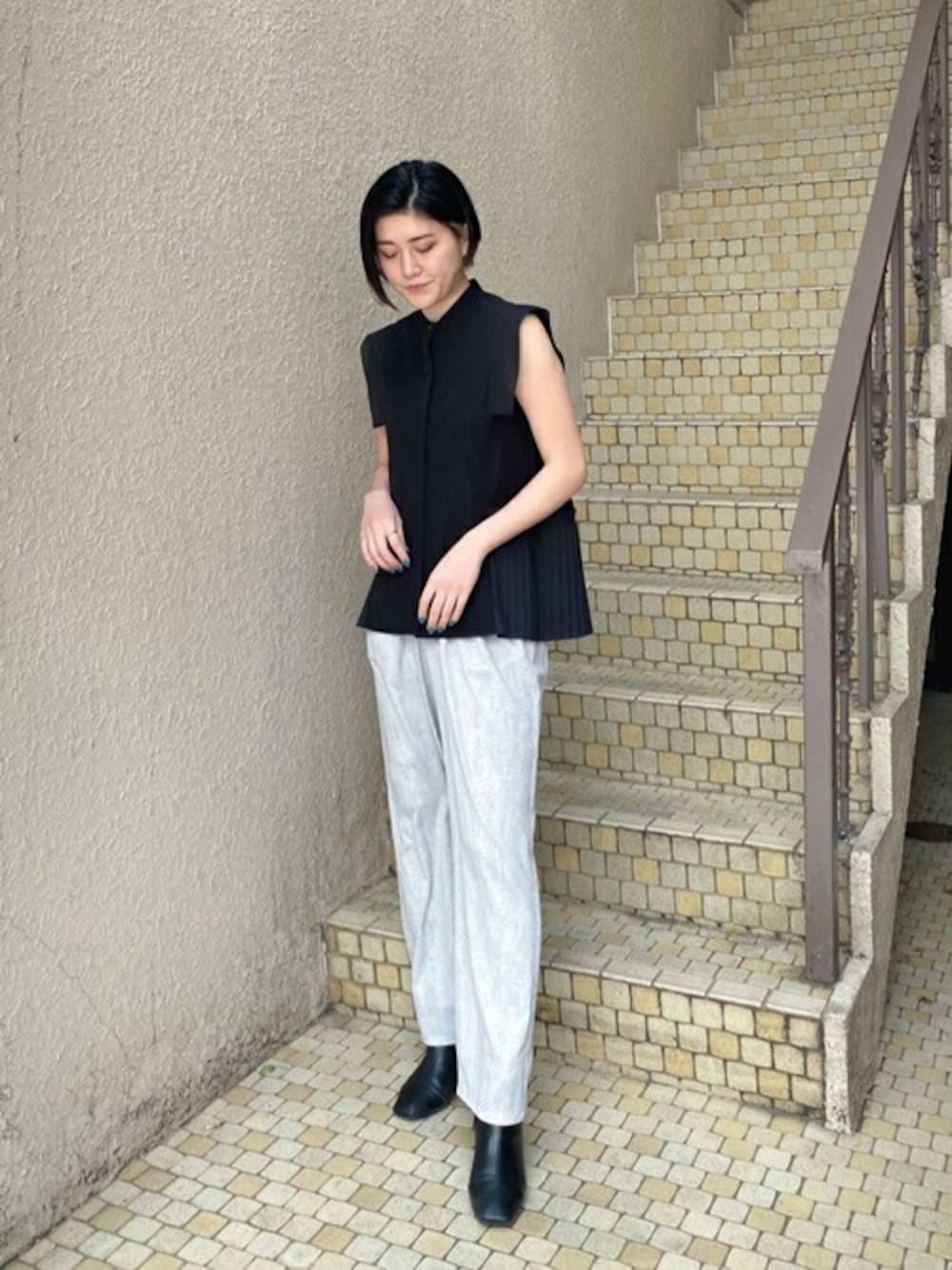 ブラック系のシャツ/ブラウス、ベージュ系のその他パンツ、ブラック系のブーツを着用したレディースの春コーディネートの1枚目の写真