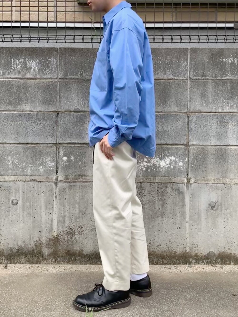 ブルー系のシャツ/ブラウス、ホワイト系のチノパンツ、ブラック系のブーツを着用したメンズの秋コーディネートの1枚目の写真