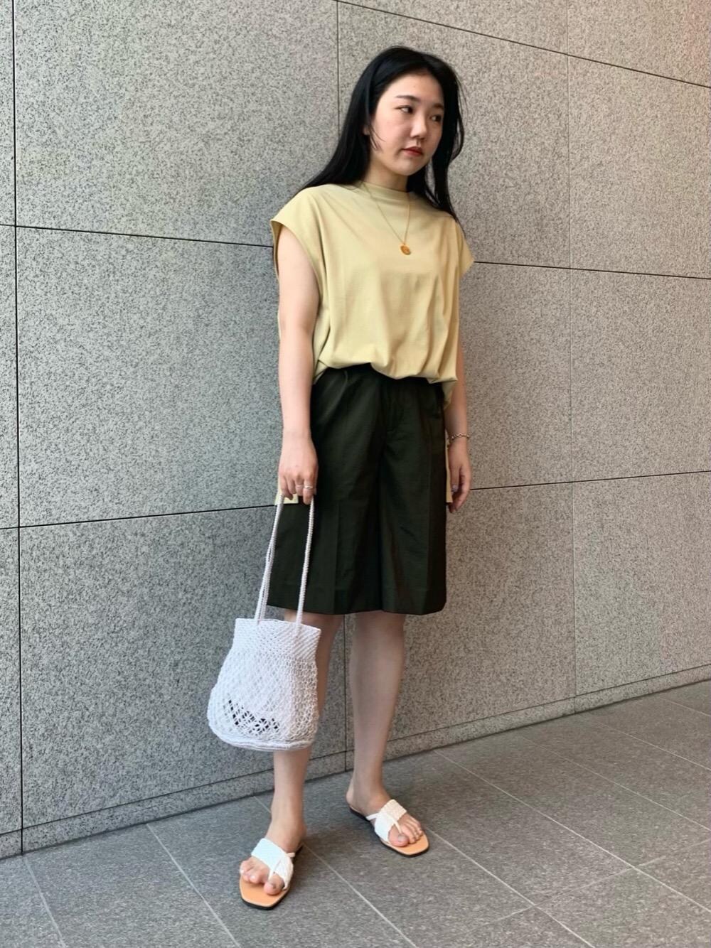 ホワイト系のショルダーバッグ、ベージュ系のTシャツ/カットソー、ホワイト系のサンダルを着用したレディースの夏コーディネートの1枚目の写真
