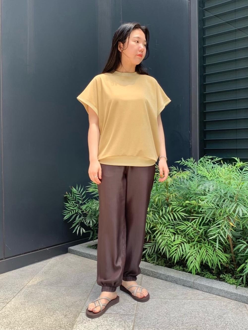 イエロー系のTシャツ/カットソー、ブラウン系のその他パンツ、グレー系のサンダルを着用したレディースの夏コーディネートの1枚目の写真