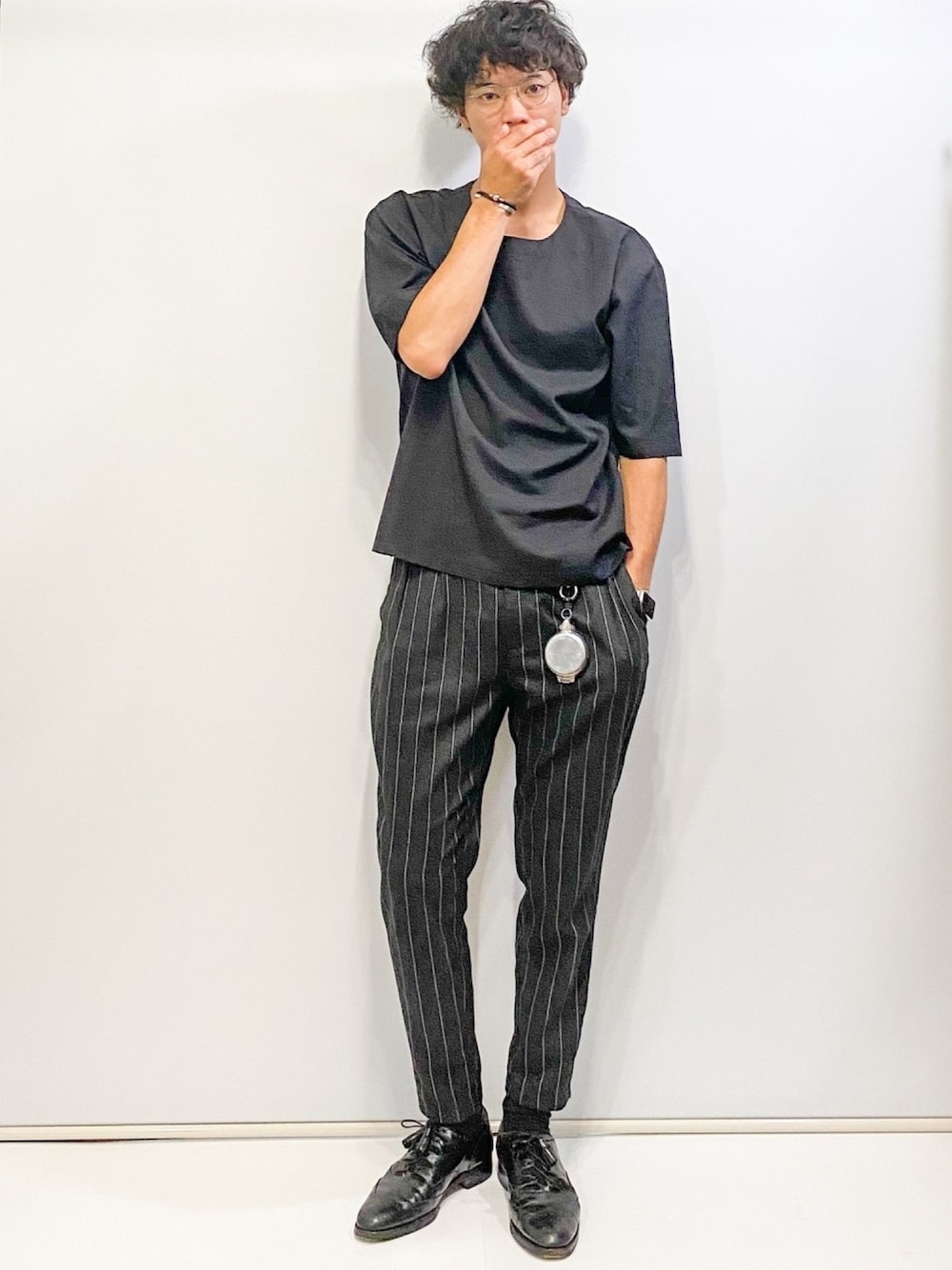 ブラック系のTシャツ/カットソー、ブラック系のスラックス、シルバー系のメガネを着用したメンズの夏コーディネートの1枚目の写真
