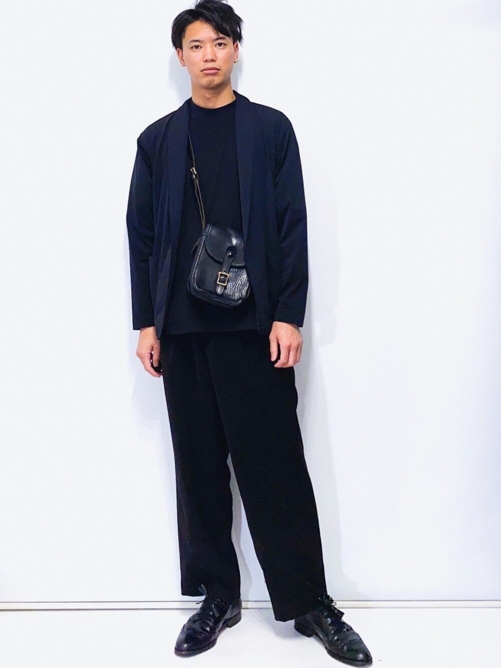 ブラック系のカーディガン/ボレロ、ブラック系のTシャツ/カットソー、ブラック系のショルダーバッグを着用したメンズの春コーディネートの1枚目の写真