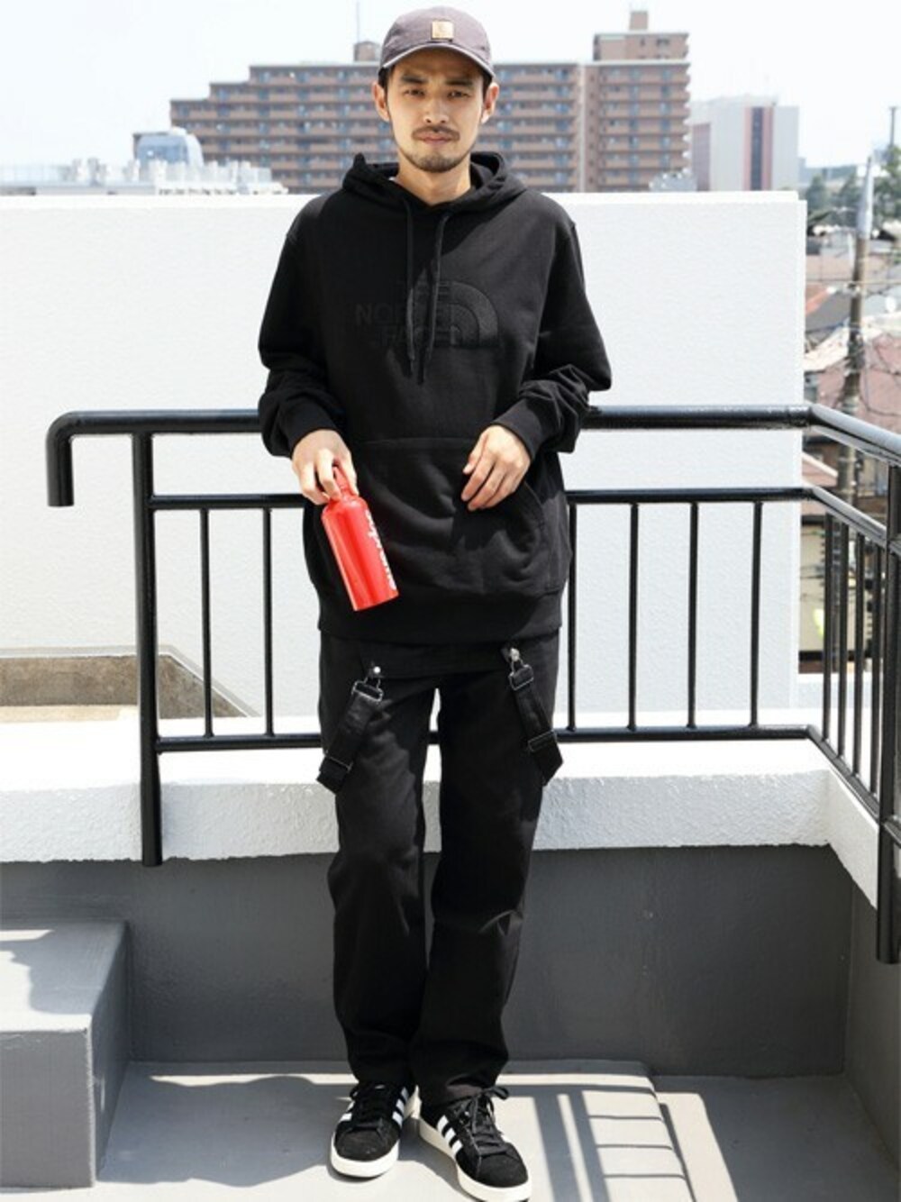 ブラック系のパーカー、ブラック系のサロペット/オーバーオール、グレー系のキャップを着用したメンズの秋コーディネートの1枚目の写真