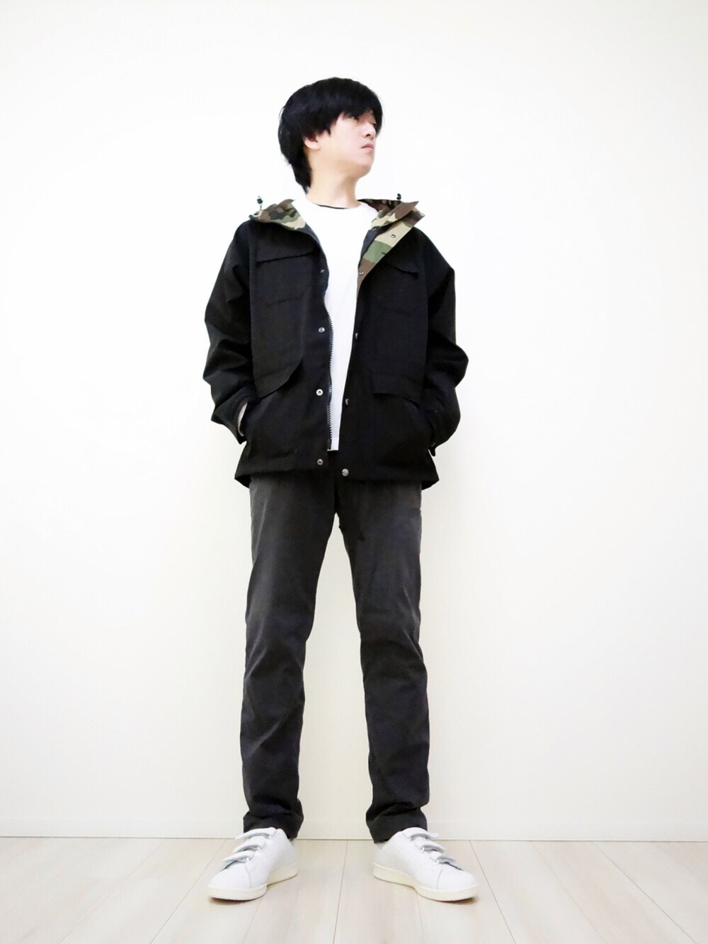 ブラック系のマウンテンパーカー、グレー系のその他パンツ、ホワイト系のTシャツ/カットソーを着用したメンズの春コーディネートの1枚目の写真