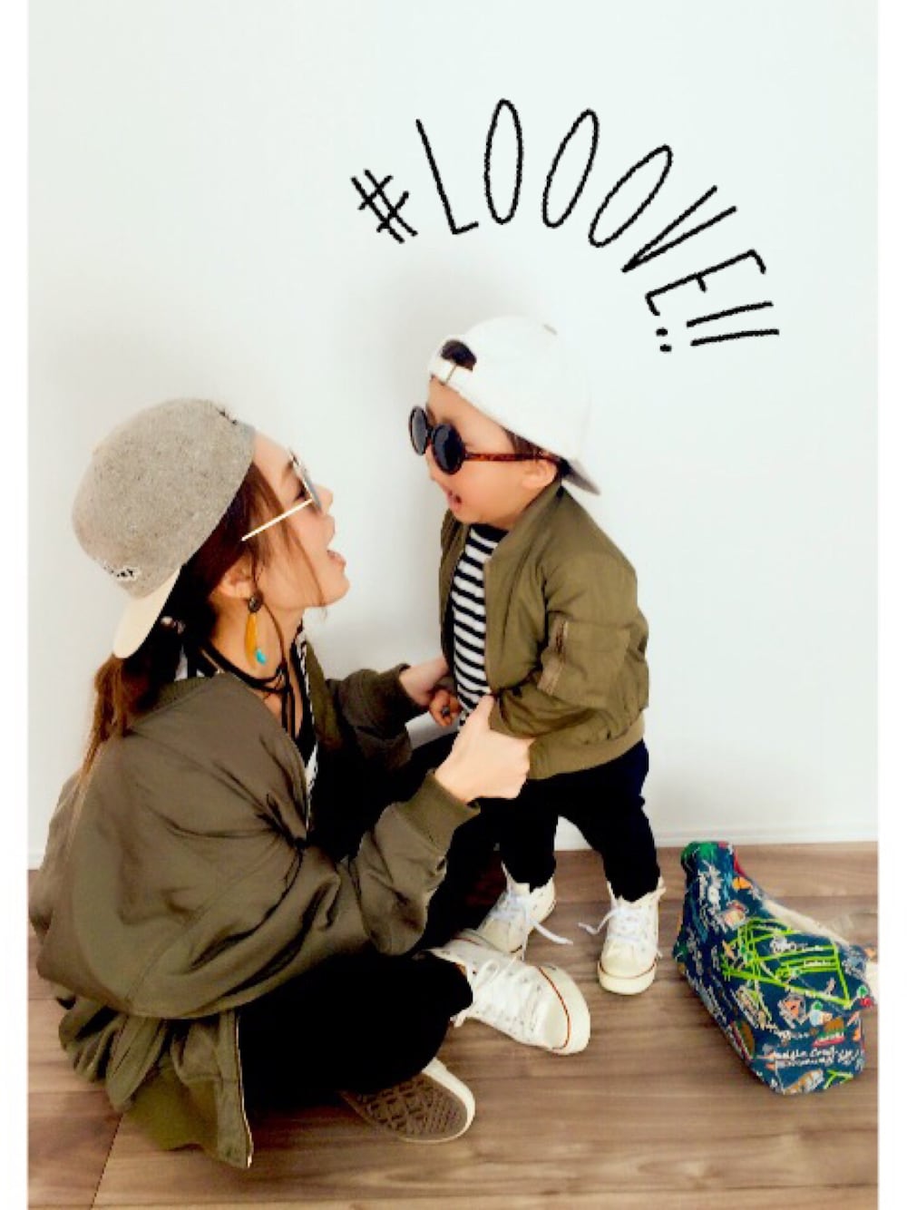 グリーン系のMA-1、ブラック系のデニムパンツ、ホワイト系のスニーカーを着用したキッズの冬コーディネートの1枚目の写真