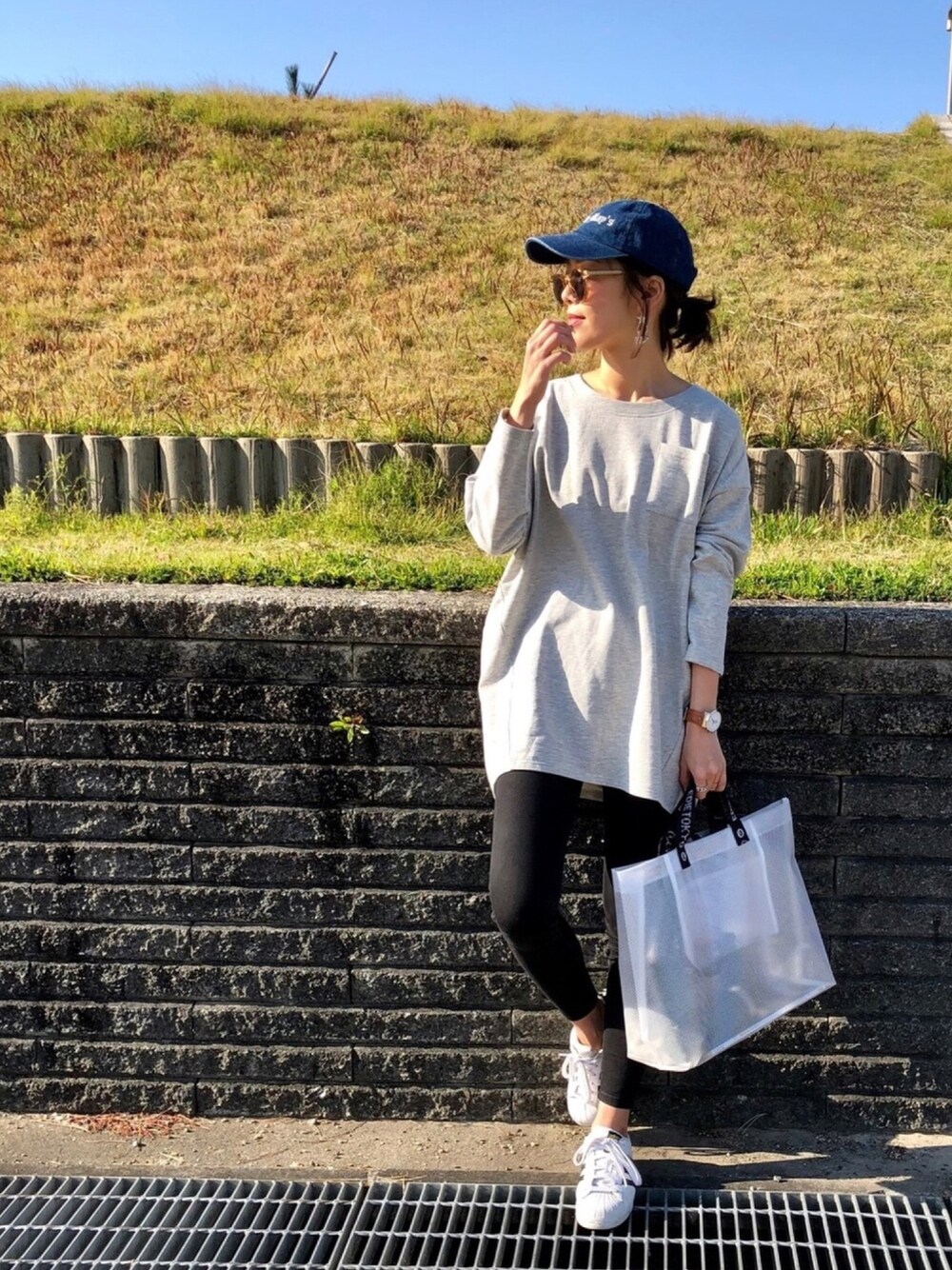グレー系のTシャツ/カットソー、ホワイト系のトートバッグ、ブルー系のキャップを着用したレディースの春コーディネートの1枚目の写真