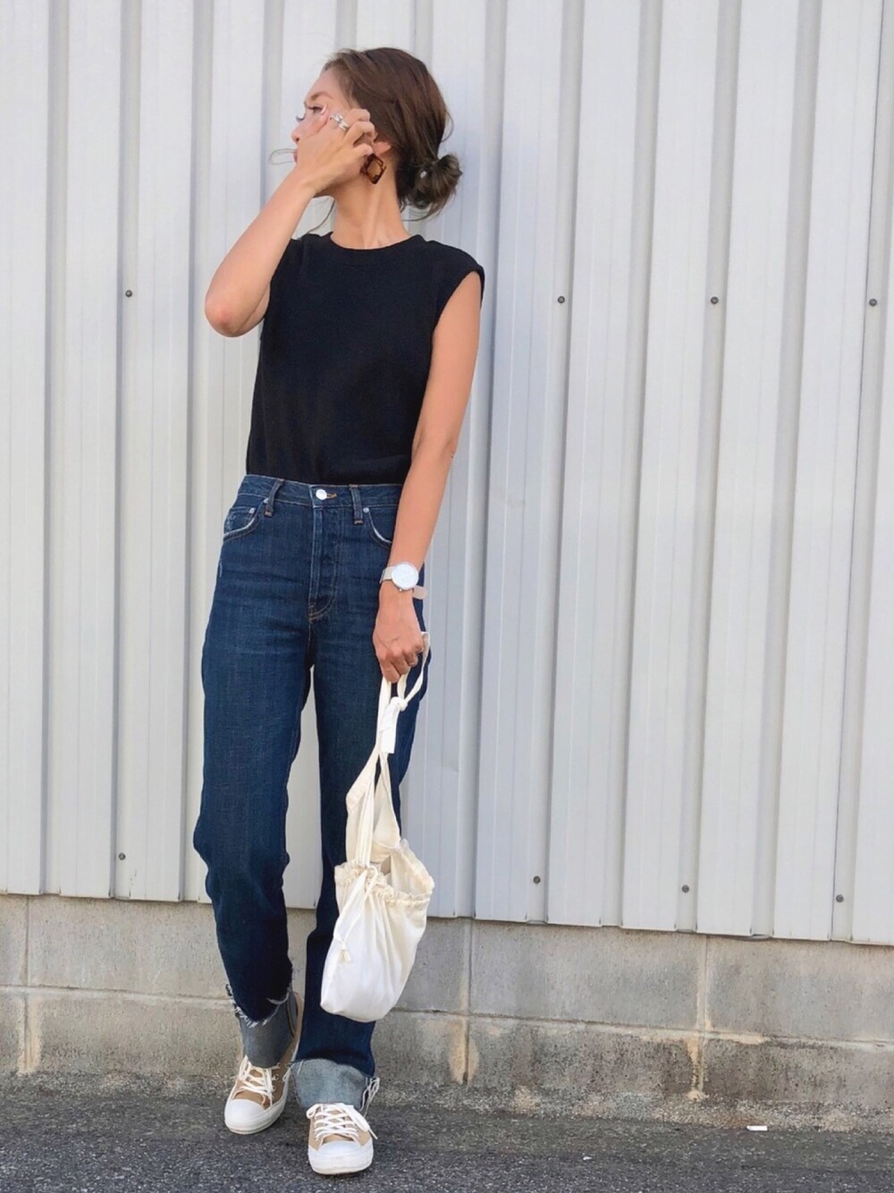 ブルー系のデニムパンツ、ホワイト系のボディバッグ/ウエストポーチ、ベージュ系のスニーカーを着用したレディースの夏コーディネートの1枚目の写真