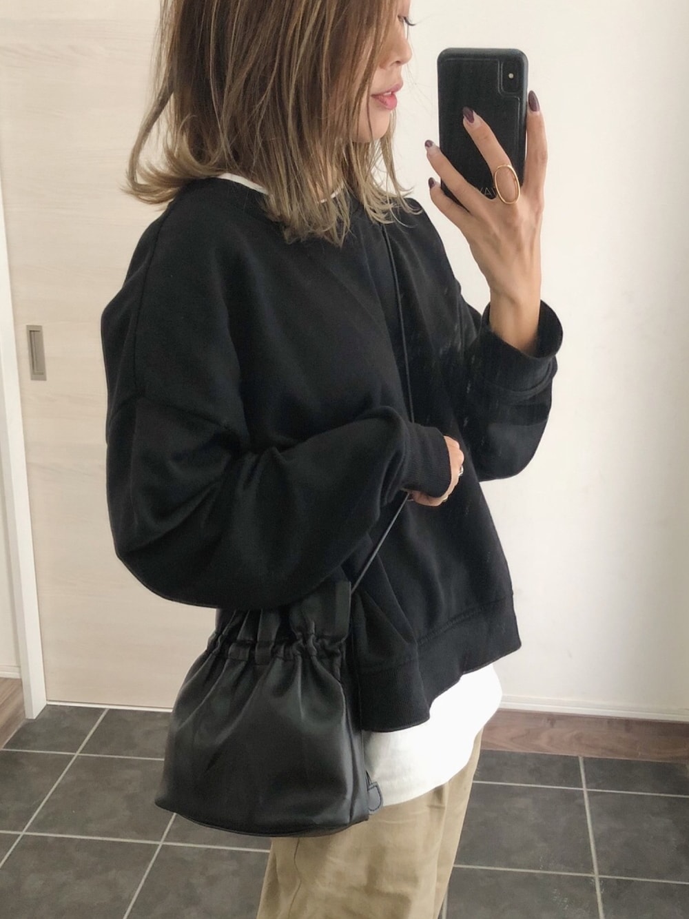 ブラック系のショルダーバッグを着用したレディースの秋コーディネートの1枚目の写真