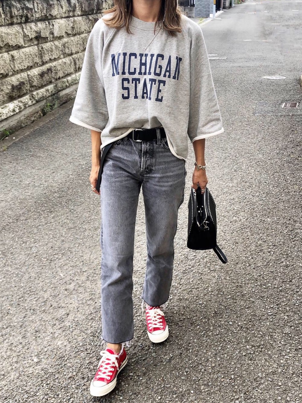 グレー系のスウェット、ブラック系のボストンバッグ、ブラック系のベルトを着用したレディースの秋コーディネートの1枚目の写真