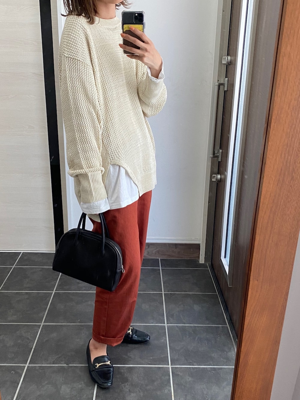 ベージュ系のトップス、ベージュ系のパンツ、ブラック系のバッグを着用したレディースの春コーディネートの1枚目の写真