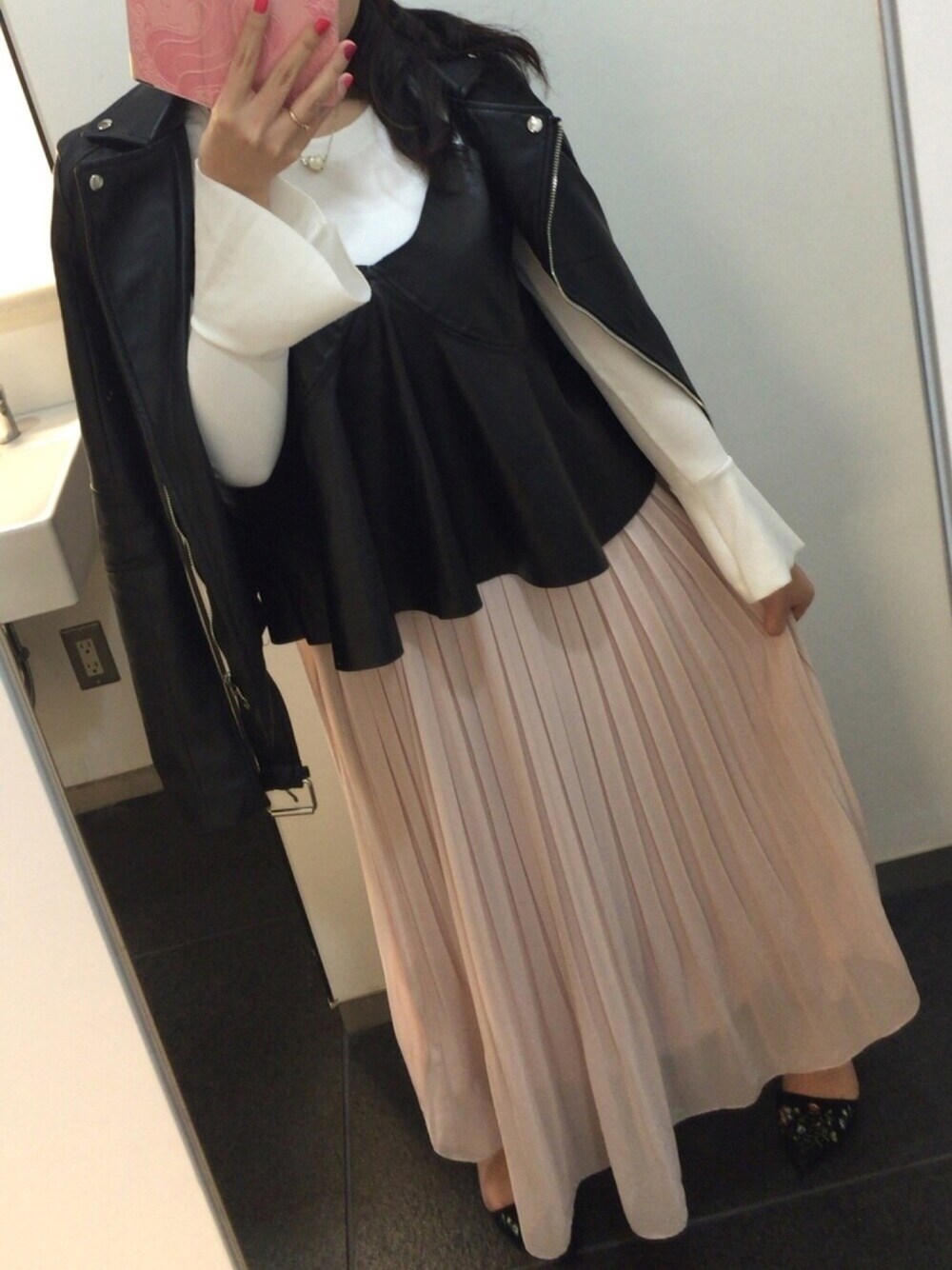 ブラック系のライダースジャケット、その他のアンサンブル、ピンク系のスカートを着用したレディースの春コーディネートの1枚目の写真