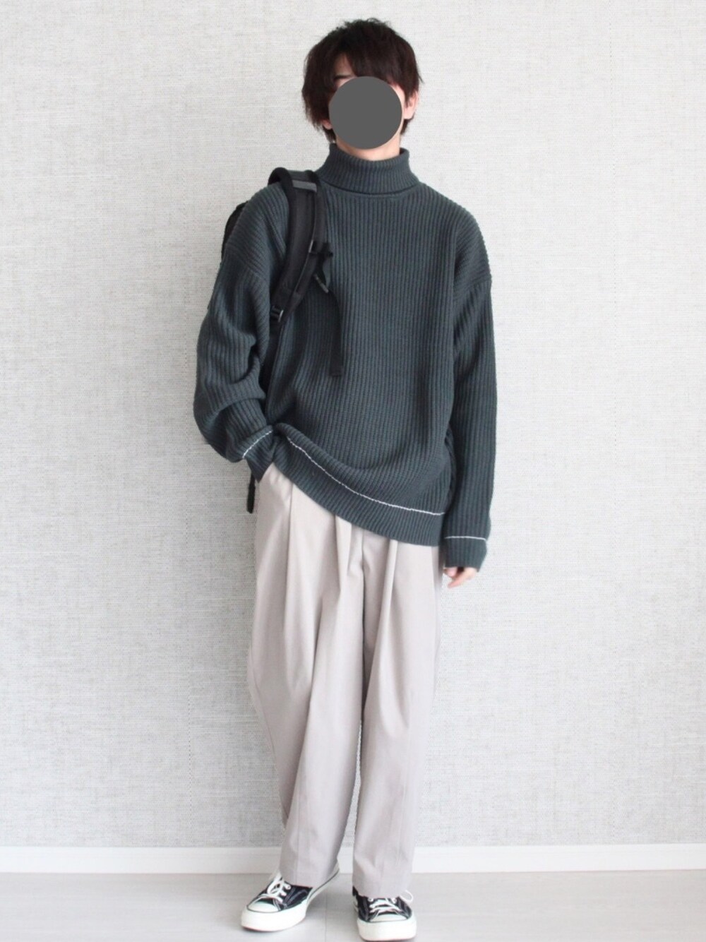 グリーン系のニット/セーター、ベージュ系のその他パンツ、ブラック系のスニーカーを着用したメンズの冬コーディネートの1枚目の写真