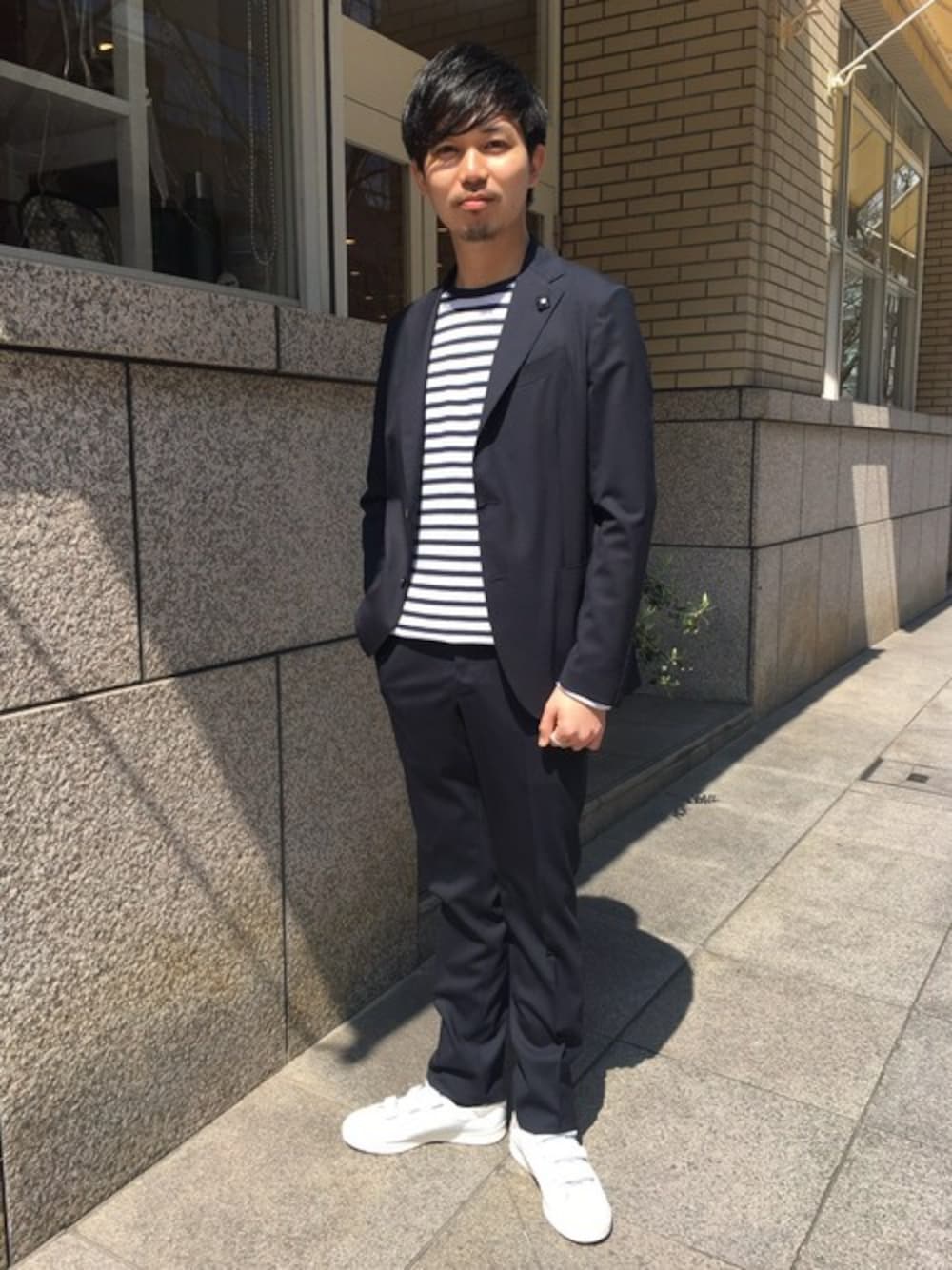 ホワイト系のスニーカーを着用したメンズの春コーディネートの1枚目の写真