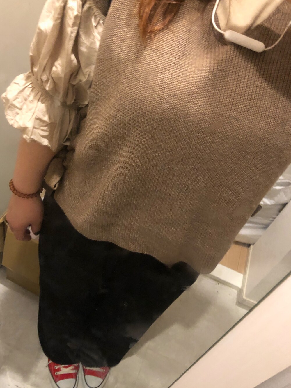 ブラウン系のベスト、ブラック系のパンツ、ベージュ系のTシャツ/カットソーを着用したレディースの秋コーディネートの1枚目の写真
