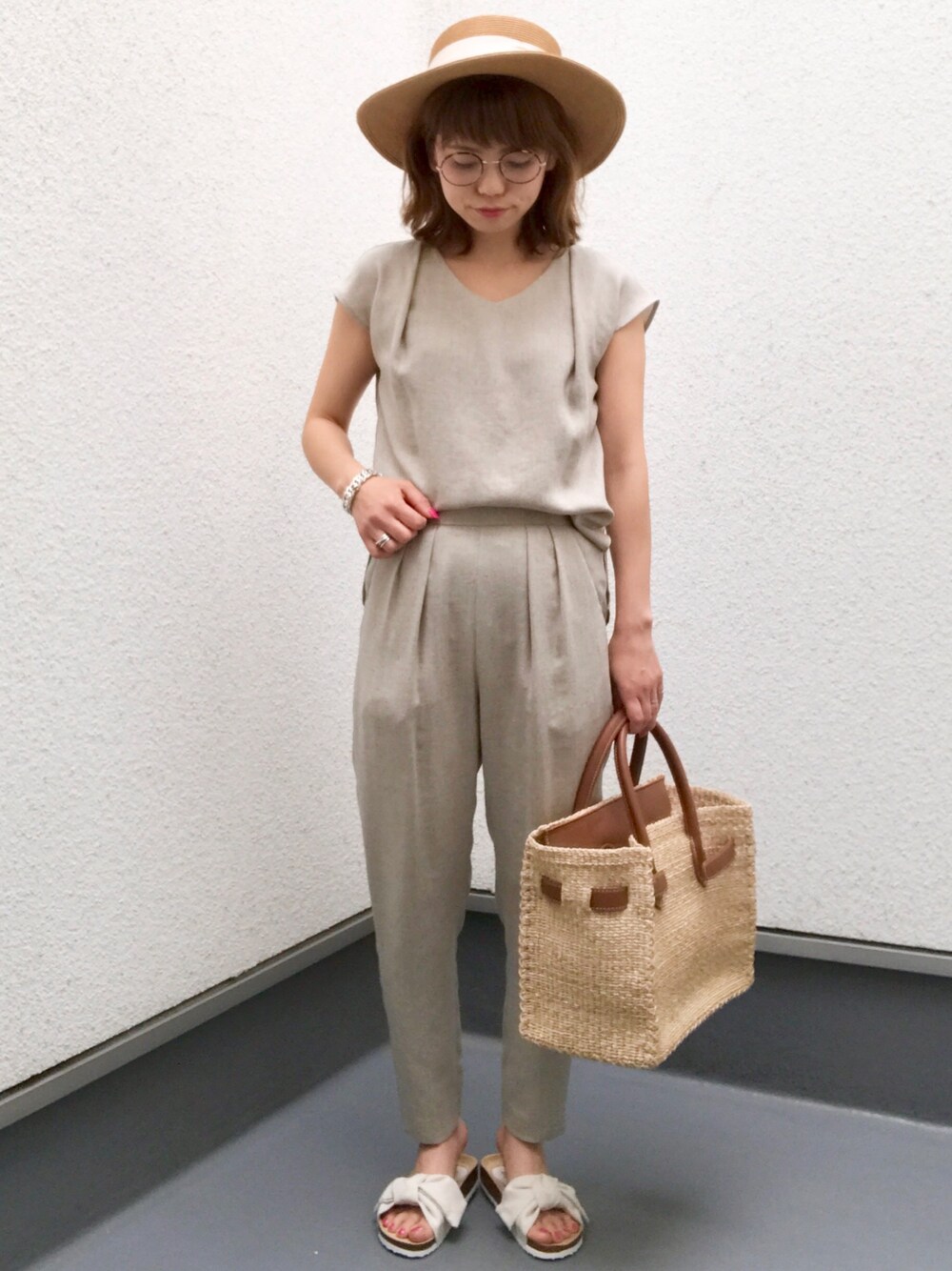 グレー系のシャツ/ブラウス、ベージュ系のトートバッグ、ホワイト系のサンダルを着用したレディースの春コーディネートの1枚目の写真
