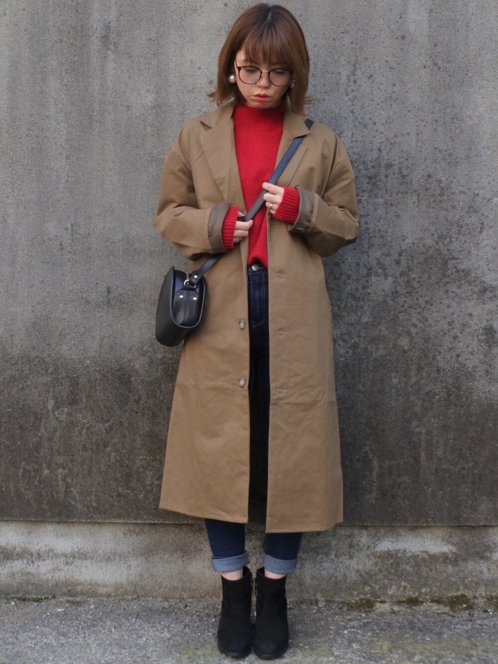 ベージュ系のその他アウター、レッド系のニット/セーター、ブルー系のデニムパンツを着用したレディースの秋コーディネートの1枚目の写真