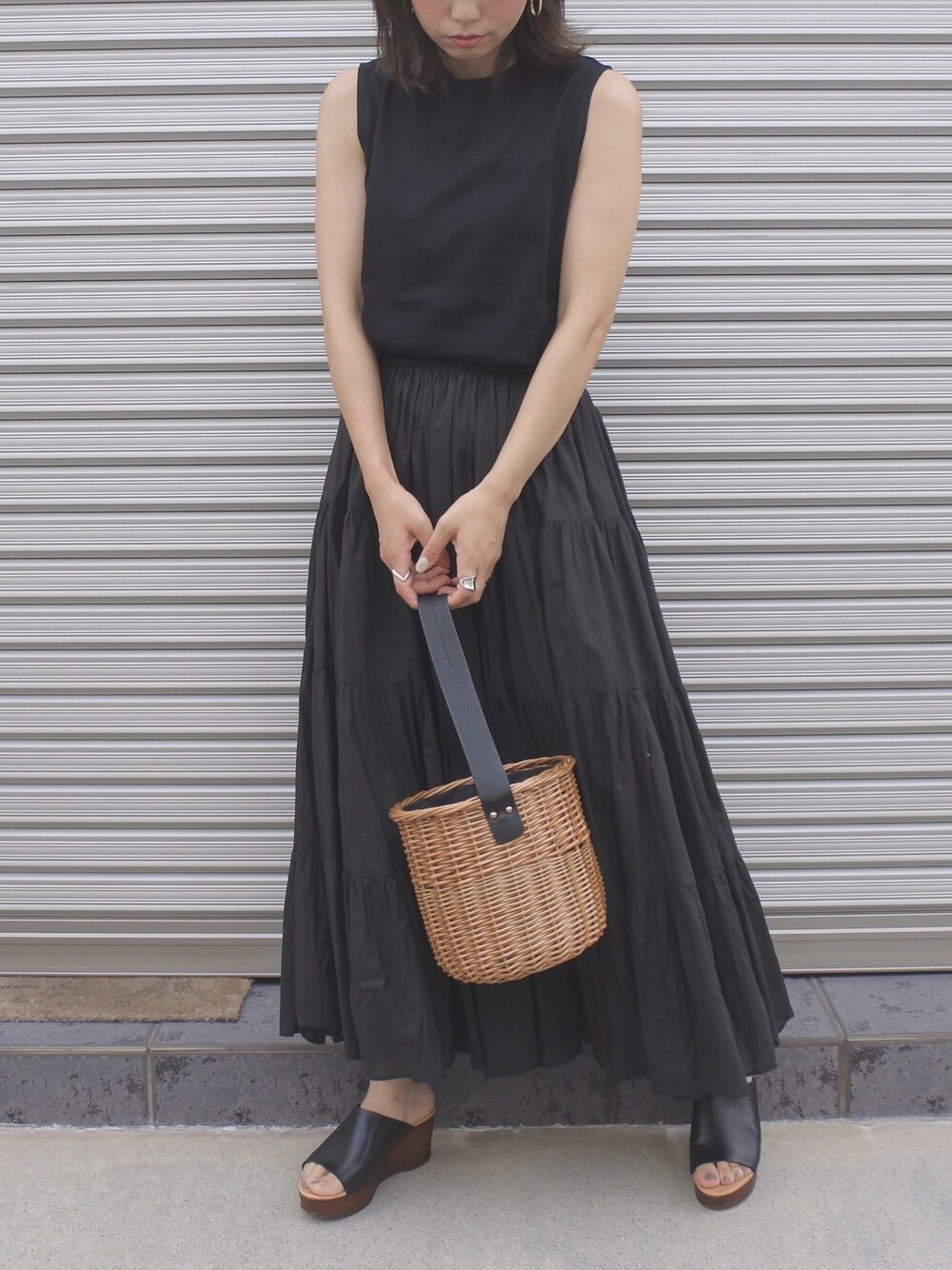 ブラック系のTシャツ/カットソー、ブラック系のスカート、ブラック系のかごバッグを着用したレディースの夏コーディネートの1枚目の写真