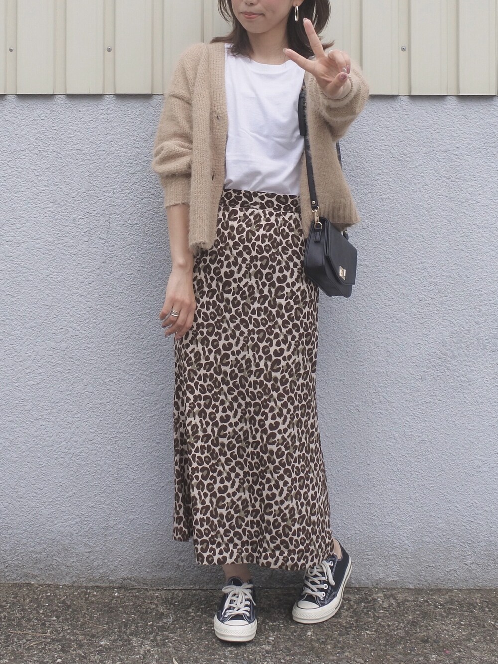 ベージュ系のカーディガン/ボレロ、ベージュ系のスカート、ブラック系のショルダーバッグを着用したレディースの秋コーディネートの1枚目の写真